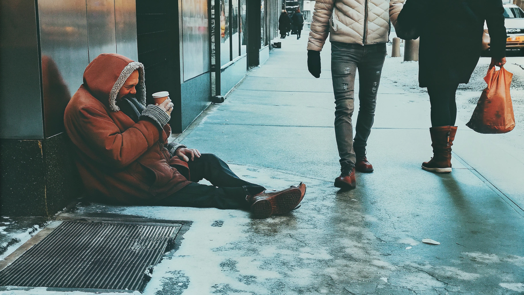 Person in red coat sitting on icy sidewalk
