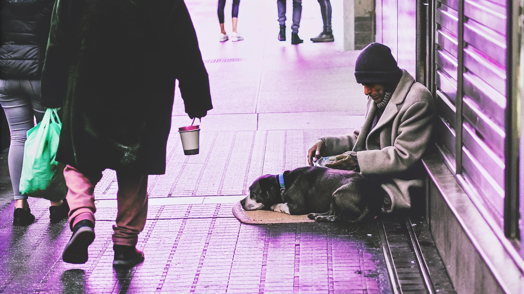 Person sitting with dog near storefront