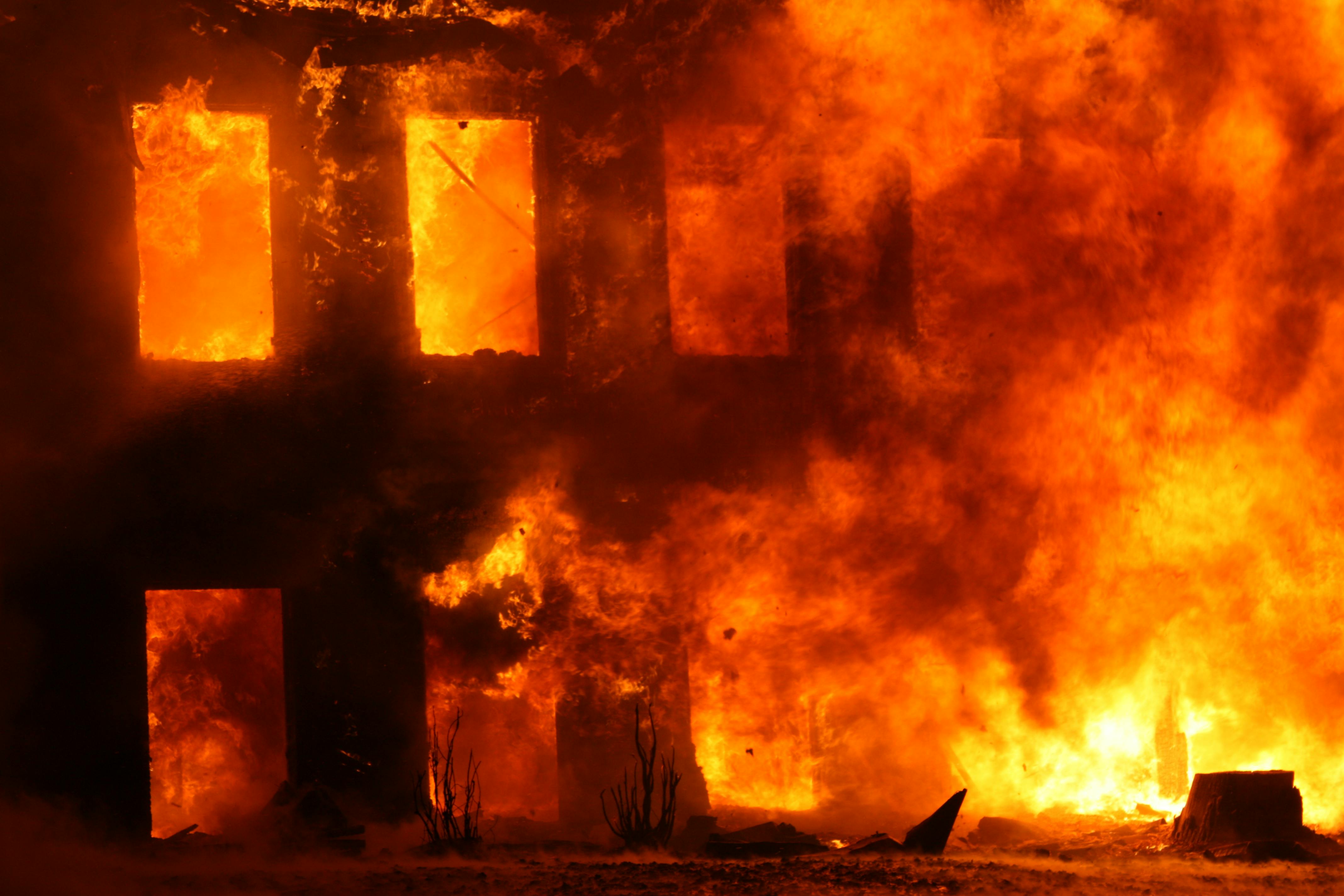 Intense house fire with blazing orange flames through windows