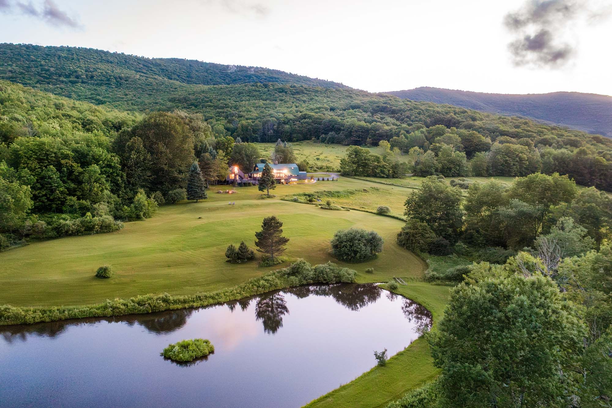 Aerial view of property with pond and mountains