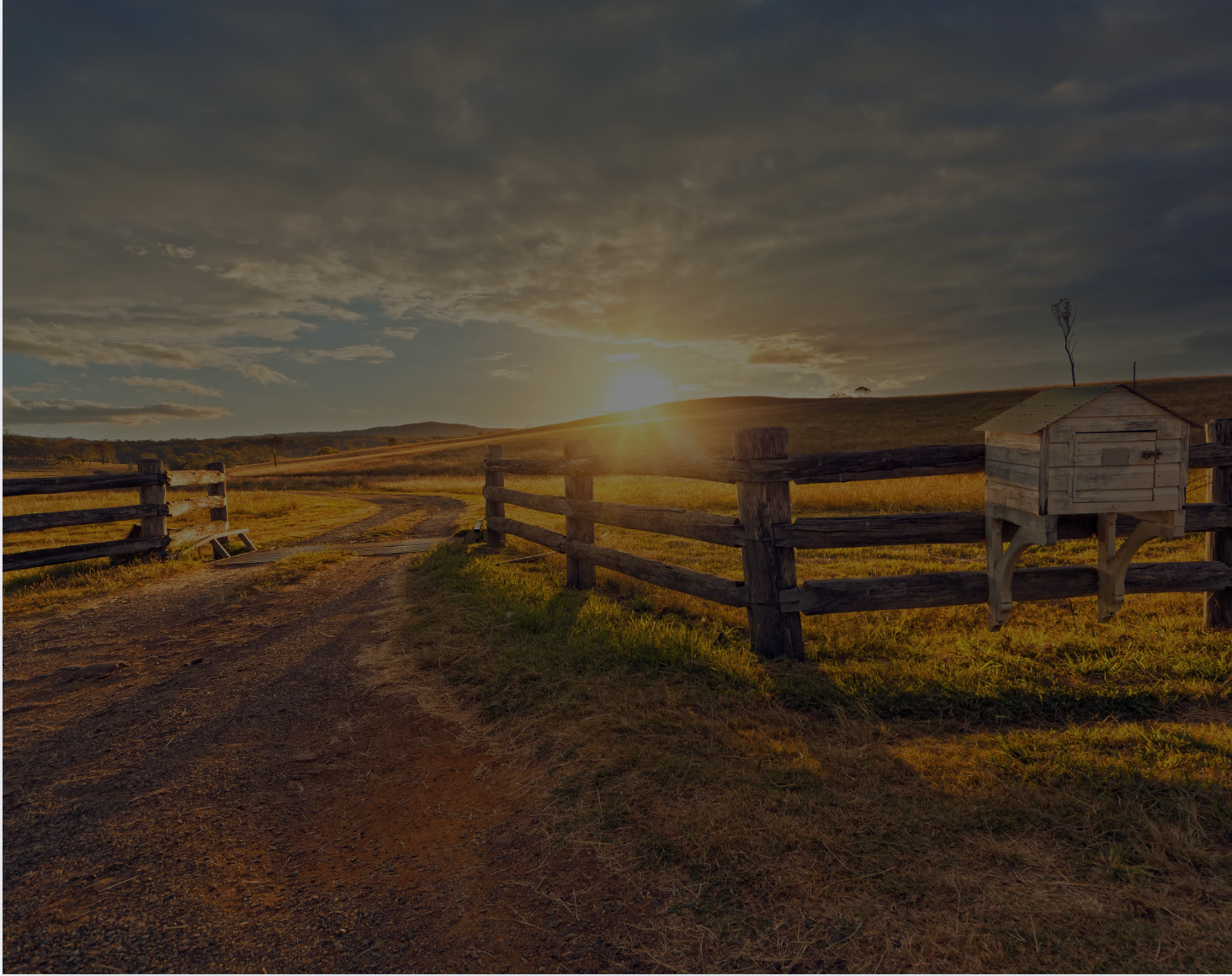Golden hour ranch landscape with wooden fence at sunset